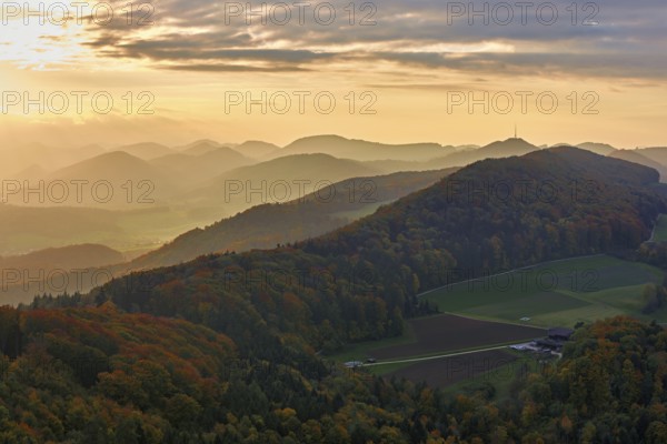 View of an autumnal forest from the Gisliflue, behind the Jurassic foothills with the water fluh in the light of the setting sun, Talheim, Canton, Aargau, Switzerland