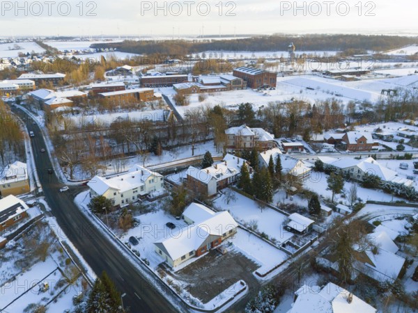 Snowy village with houses, roads and surrounding winter landscape, aerial view, Oelsburg, Ilsede municipality, Peine district, Lower Saxony, Germany