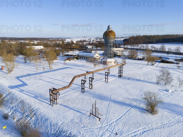 Snowy industrial structure with a large tower in an open landscape under clear sky, aerial view, water tower, Ilseder Hütte, Groß Ilsede, municipality of Ilsede, district of Peine, Lower Saxony, Germany
