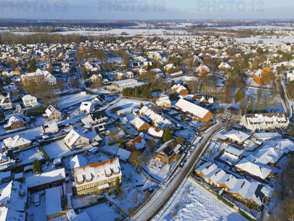 Snowy village landscape with close-standing houses and snow-covered roads from above, aerial view, Oelsburg, Ilsede municipality, Peine district, Lower Saxony, Germany