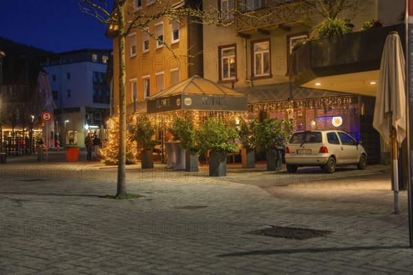 Restaurant with illuminated terrace at night, surrounded by plants and a parked car, Nagold, Calw district, Black Forest, Germany