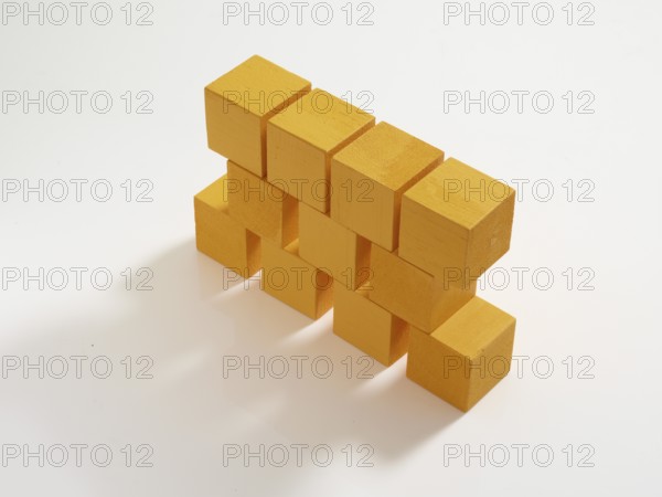 11 yellow wooden cubes against a white background