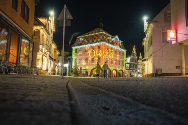 A lively cityscape at night with a brightly lit historic building and modest street lighting, Nagold, Calw district, Black Forest, Germany