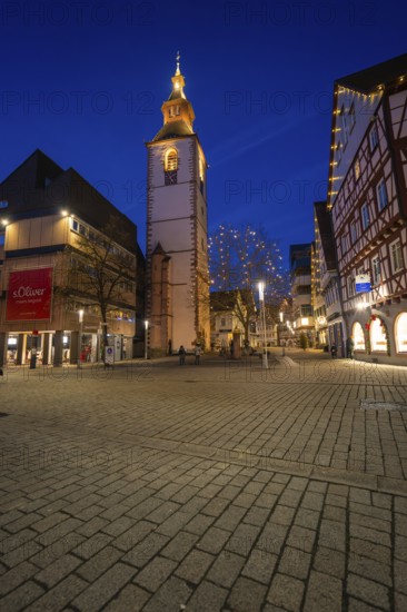 Bell tower of a church illuminated at night, surrounded by half-timbered houses, Nagold, Calw district, Black Forest, Germany