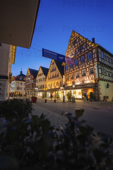 Illuminated houses with traditional architecture and ice banners at night, Nagold, Calw district, Black Forest, Germany