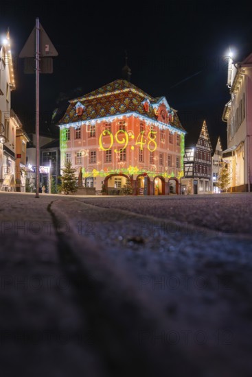 Night view of a historic building illuminated with a colorful light projection, Nagold, Calw district, Black Forest, Germany