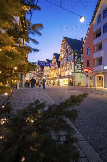 City street with illuminated half-timbered houses and festive lighting, walkers, Nagold, Calw district, Black Forest, Germany