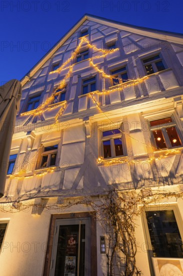 Fairy lights in tree silhouette on the façade of a furnished house, Nagold, Calw district, Black Forest, Germany
