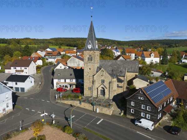Close-up of a church in a village surrounded by roads and modern houses, aerial view, Niederkalbach, Kalbach municipality, Fulda district, Hessian Rhön nature park Park, Hesse, Germany