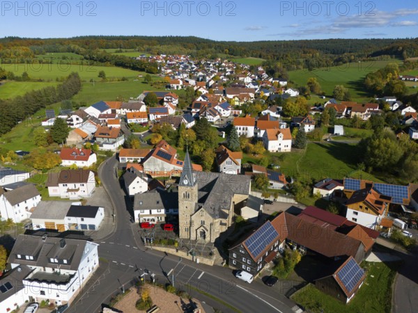 Aerial view of a village with church and many houses in an autumn landscape, Niederkalbach, Kalbach municipality, Fulda district, Hessian Rhön nature park Park, Hesse, Germany