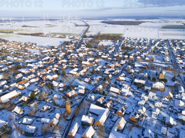 Aerial view of a snowy village with wind turbines on the horizon and a water tower in the center, aerial view, water tower, museum, Groß Lafferde, municipality of Ilsede, district of Peine, Lower Saxony, Germany