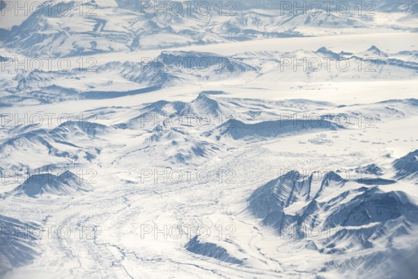 Icy, snowy arctic mountain landscape with glaciers, aerial view, Greenland, Arctic
