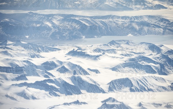 Icy, snowy arctic mountain landscape with glaciers and fjords, aerial view, Greenland, Arctic