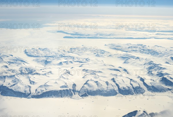Wide snowy landscape with mountain ranges and huge glaciers, aerial view, Greenland, Arctic