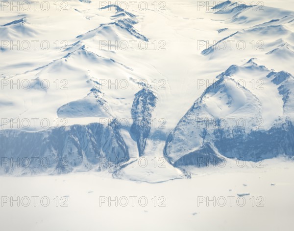 Glacier tongue flows into huge glaciers, snowy arctic mountain landscape, aerial view, Greenland, Arctic