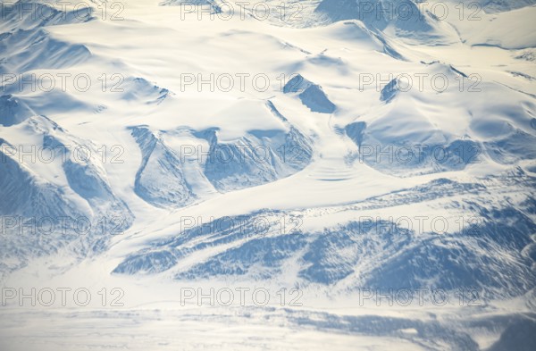 Glacier tongues flow into glaciers, snowy arctic mountain landscape, aerial view, Greenland, Arctic