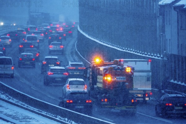 Winter maintenance, spreading vehicle, winter weather, motorway traffic, A40 motorway, Ruhrschnellweg, in Essen, at the Essen-Ost motorway junction, snowfall, traffic jams, heavy flowing traffic, North Rhine-Westphalia, Germany