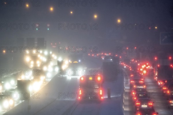 Winter weather, motorway traffic, A40 motorway, Ruhrschnellweg, in Essen, at the Essen-East motorway junction, snowfall, traffic jams, heavy flowing traffic, bus lane between roads, public transport, North Rhine-Westphalia, Germany