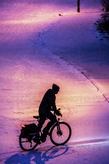 Winter weather, blowing snow, person with e-bike, bicycle on snowy road, North Rhine-Westphalia, Germany