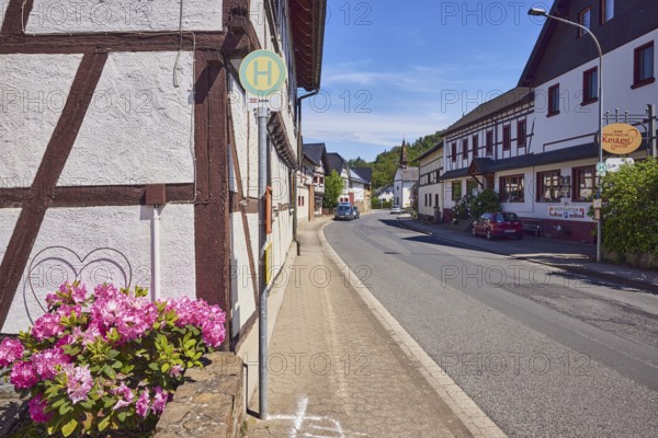 Bus stop Insul Gasthaus Keuler, Landgasthaus Café Keuler, residential buildings and commercial buildings, general architecture, historic half-timbered houses, parking strips with cars, lantern, flower, hill, forest, blue sky, cirrus clouds, cirrostratus clouds, main street, Insul, district of Ahrweiler, Rhineland-Palatinate, Germany