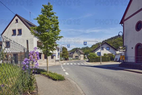 Residential building, historic half-timbered house, houses, general architecture, sidewalk, crosswalk, zebra crossing, traffic sign pedestrian crossing, wire mesh fence, trees, meadow, flower, hill, forest, blue sky, cirrus clouds, cirrostratus clouds, intersection of main street, Brückenstraße and Kapellenweg, Insul, district of Ahrweiler, Rhineland-Palatinate, Germany