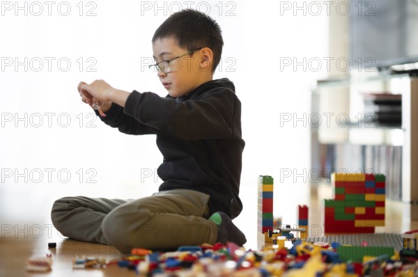 Boy, 6 years, glasses, multi-ethnic, plays with Lego, concentrates, constructs, builds, Stuttgart, Baden-Württemberg, Germany