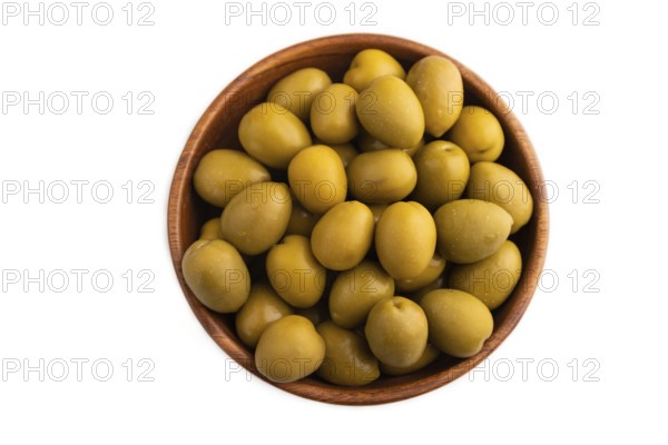 Fresh green olives in wooden bowl isolated on white background. Top view, flat lay, close up