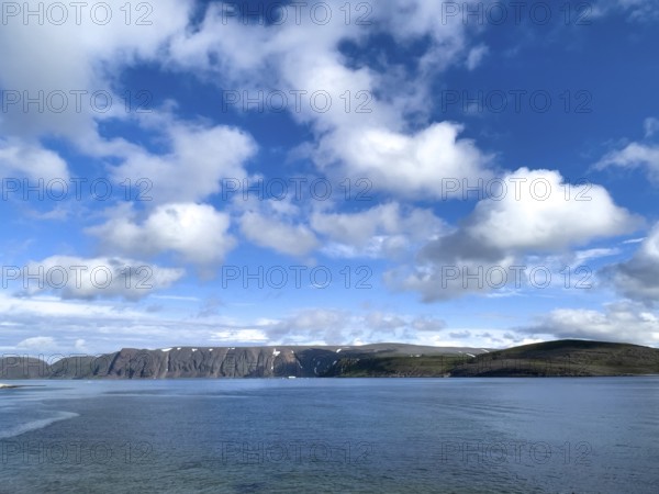 Calm sea and clear coastline under a sky with white clouds on Syltejjord on the Varanger Peninsula in northern Norway, Ytre Syltefjord, Finnmark, Norway