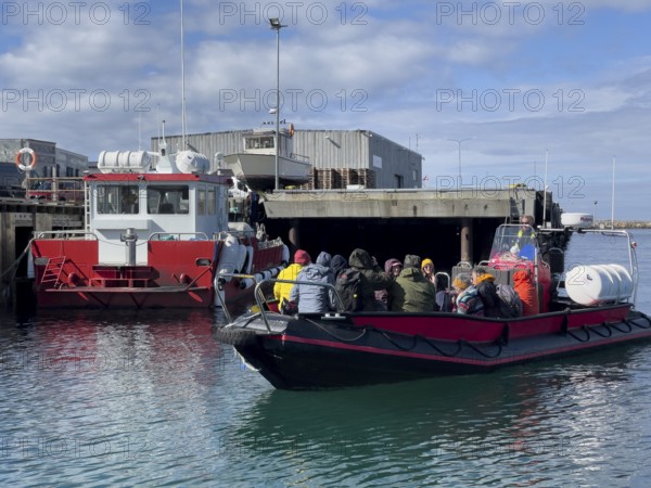 A group of tourists bird-watching on the incoming inflatable dinghy Speedboat, which drives tourists to Hornoy Vogel Island, Vardø, Finnmark, Norway