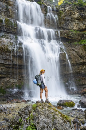 Young woman in front of Cascata di Mezzo waterfall, long exposure, Vallesinella, Brenta, Trentino, Italy