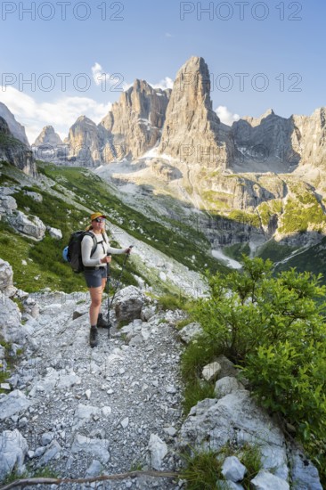 Female mountaineer in front of picturesque mountain landscape in the morning, Cima Tosa rock summit, Brenta, Trentino, Italy