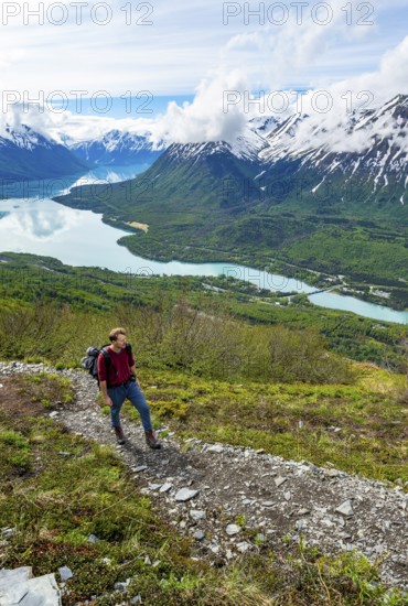 Climbers on a hiking trail, Slaughter Ridge Trail, view of snowy mountains and turquoise lake Kenai Lake, Cooper Landing, Kenai Peninsula, Alaska, USA