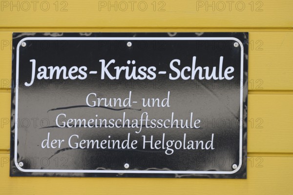 James Krüss School sign on yellow background in Heligoland, Heligoland, Schleswig-Holstein, Germany