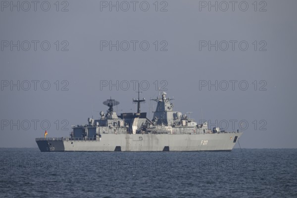 A gray naval vessel from the submarine defense the frigate Bayern F217 on calm seas at roadside off the island of Heligoland in clear skies, Heligoland, Schleswig-Holstein, Germany