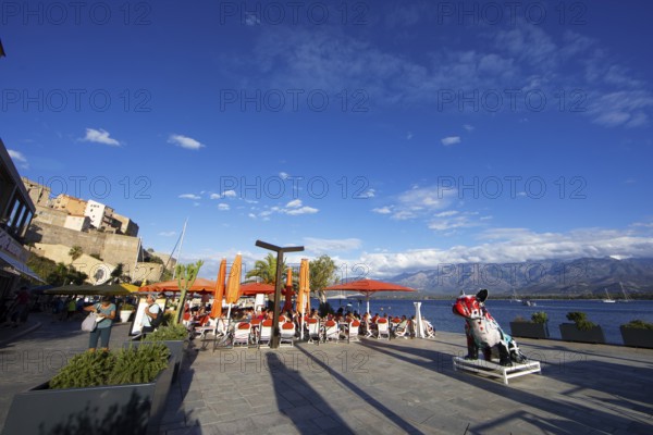 Restaurant at the marina in Calvi, with the mountains of the Balagne region in the Haute-Corse department, Corsica, France
