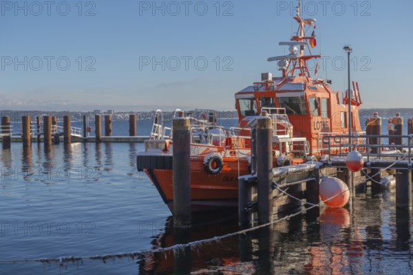 Kiel-Holtenau pilot station in front of the Kiel Canal, pilot boat, channel guidance, shipping, safety, dolphins, pier, Kiel Fjord, Baltic Sea, on the horizon east shore with Heikendorf, calm sea, winter, snowfall, sunshine, blue sky, Kiel, Germany