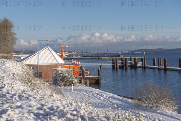 Kiel-Holtenau pilot station in front of the Kiel Canal, pilot boat, channel guidance, shipping, safety, dolphins, pier, Kiel Fjord, Baltic Sea, on the horizon the east shore with Laboe, calm sea, winter, snowfall, sunshine, blue sky, Kiel, Germany