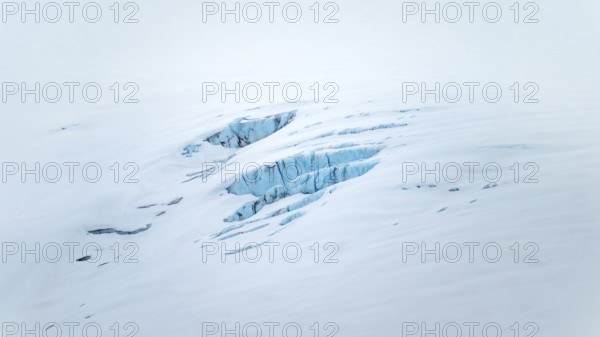 Smooth white snowy area on the glacier broken by crevasses with blue rugged glacial ice, detail, Exit Glacier, Kenai Peninsula, Alaska, USA