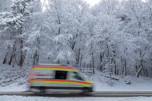 Ambulance driving through snowy landscape, trees, winter, snow, Sieversen, Samtgemeinde Rosengarten, Lower Saxony, Germany