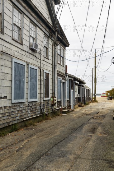 Alley leading to the ocean, weathered timber houses, traditional wood paneling, power lines, former fishing village of Provincetown, Cape Cod, Massachusetts, New England, USA