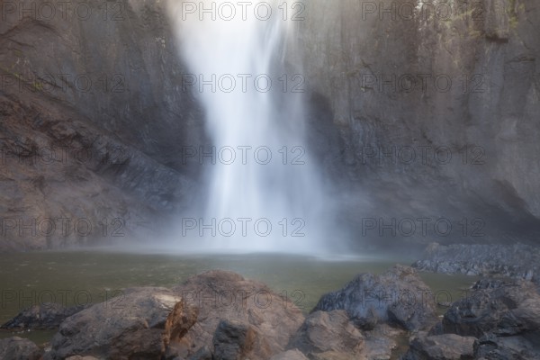Daytime view from below of Wallaman Falls cascading into a rainforest gorge, Queensland, Australia