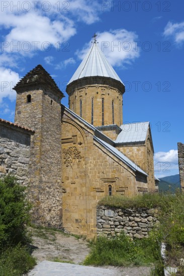 Medieval stone church with a distinctive brick tower and lush surroundings under a blue sky, Ananuri Castle, Zhinvali Reservoir, Jinvali or Shinvali, Mtskheta-Mtianeti Region, Georgian Military Road, Georgia