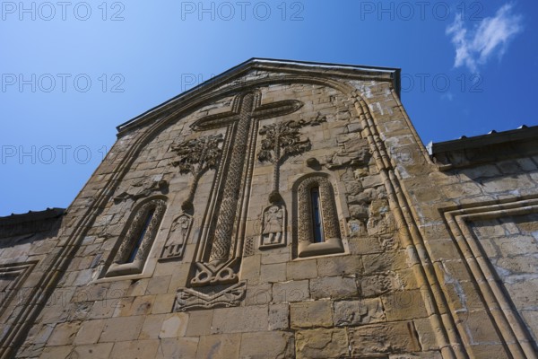 Historic church façade with large cross reliefs and decorations under a blue sky, Ananuri Castle, Zhinvali Reservoir, Jinvali or Shinvali, Mtskheta-Mtianeti Region, Georgian Military Highway, Georgia
