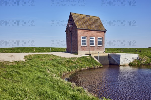 Hunnebüllerkoog, Hunnebüller Sielzug, pumping plant, façade with windows, pointed roof with red roof tiles, brick, siel, wasteland, grass, pale blue sky, cirrostratus clouds, Risum-Lindholm, district of North Frisia, Schleswig-Holstein, Germany