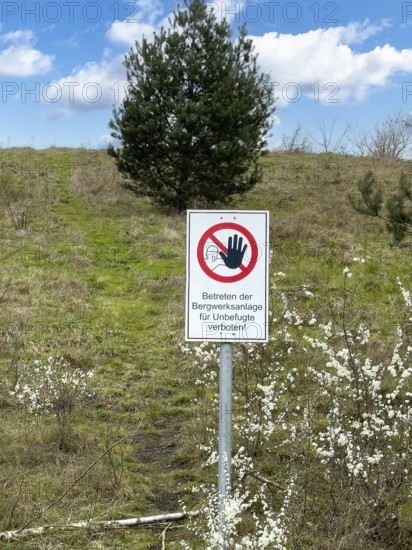 Warning sign prohibited from entering the mine complex for unauthorised persons! In front of a green mine heap Schöttelheide mining waste dump designated as a nature reserve since April 2025, Kirchhellen, Bottrop, North Rhine-Westphalia