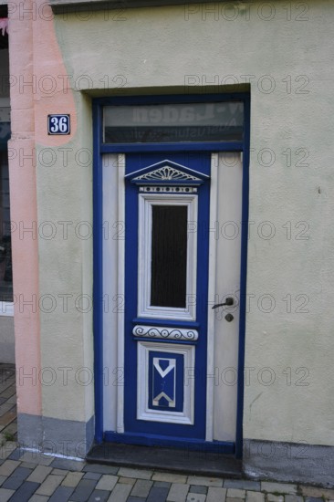 Historically decorated blue door as entrance to a building, a decorative blue wooden door with house number 36, Husum, Schleswig-Holstein, Germany