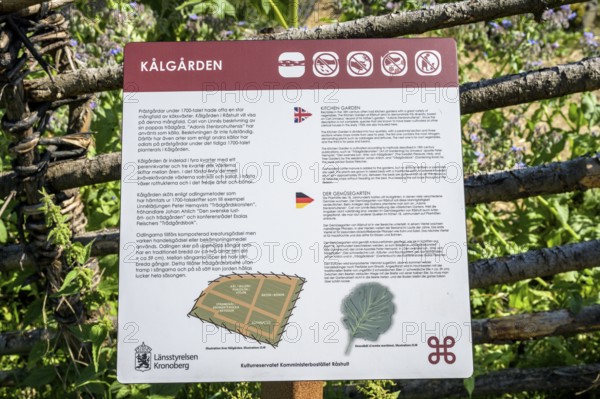 Information sign about Kålgården with texts in various languages and symbols, a picturesque garden with flowers and a rural house in the background, the colorful cottage garden vegetable garden of the famous botanist and taxonomist Carl von Linne with a rustic wooden fence under a blue sky, Linnes Rashult, Rashult, Diö, Kronobergs län, Sweden