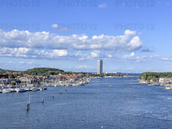 View over the Trave towards the mouth in the underground, the church of Travemünde and the Atlantic Hotel, with clouds and birds, Travemünde, Lübeck, Schleswig-Holstein, Germany