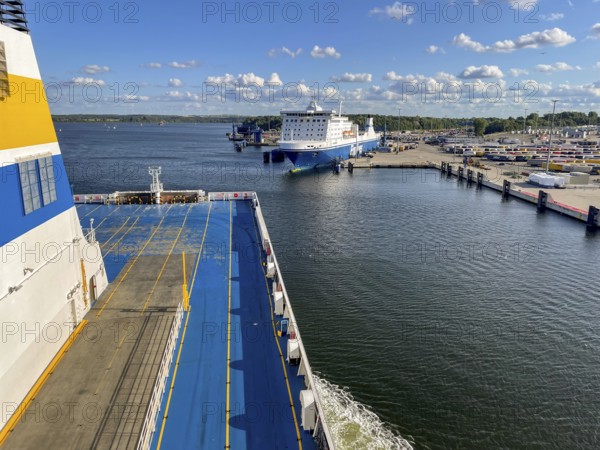 Large ferry is located in the port of Travemünde on, Scandinavia quay in the foreground dcas ceiling of an incoming TT line ferry surrounded by water and sunny skiesLübeck, Schleswig-Holstein, Germany