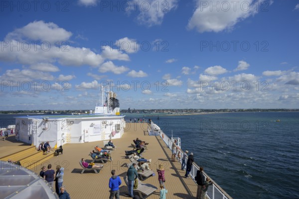 People relax on a TT-Line ship deck with a view of the sea under a blue sky, Trelleborg, Skåne län, Sweden